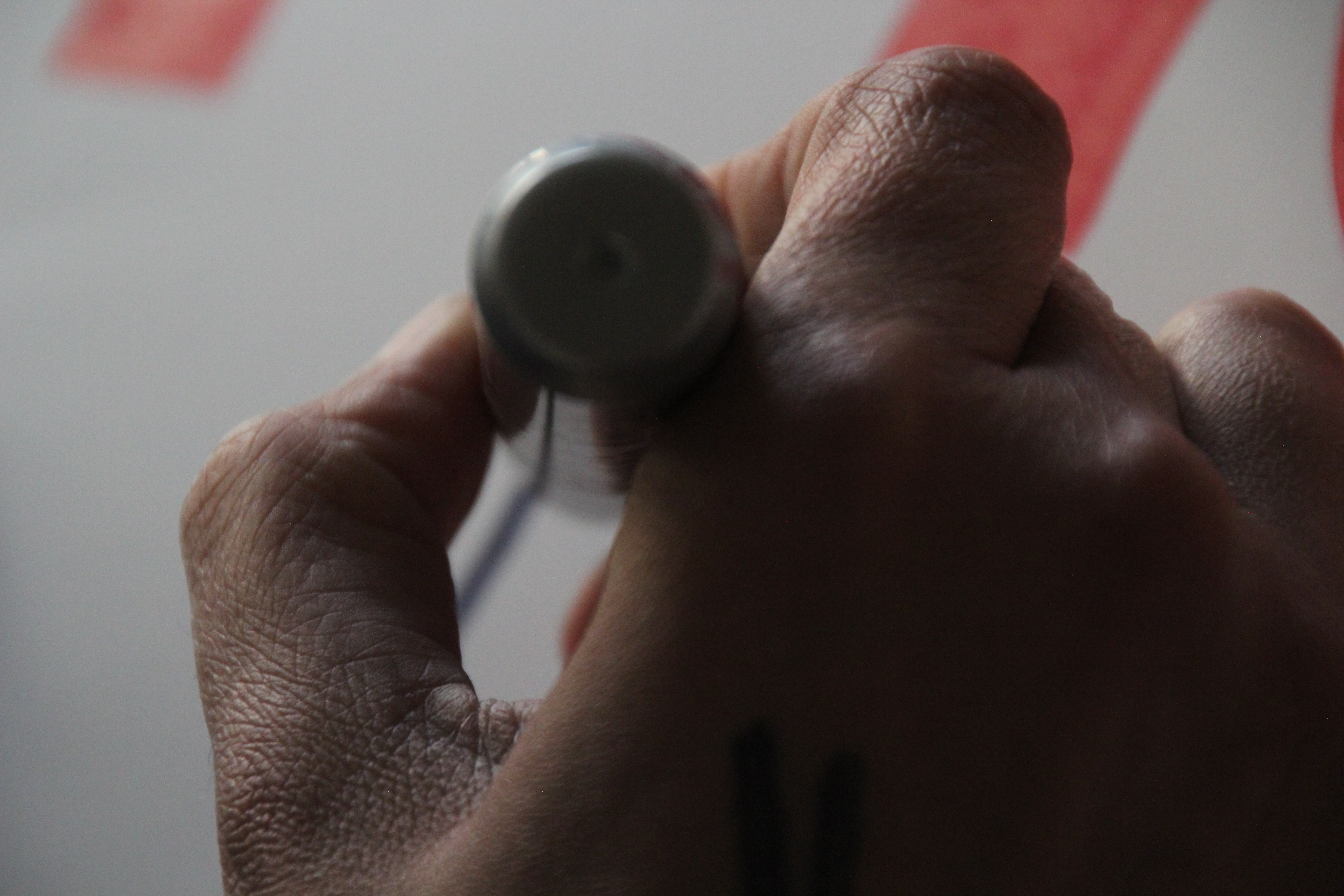 close up of a hand holding a thick sharpie