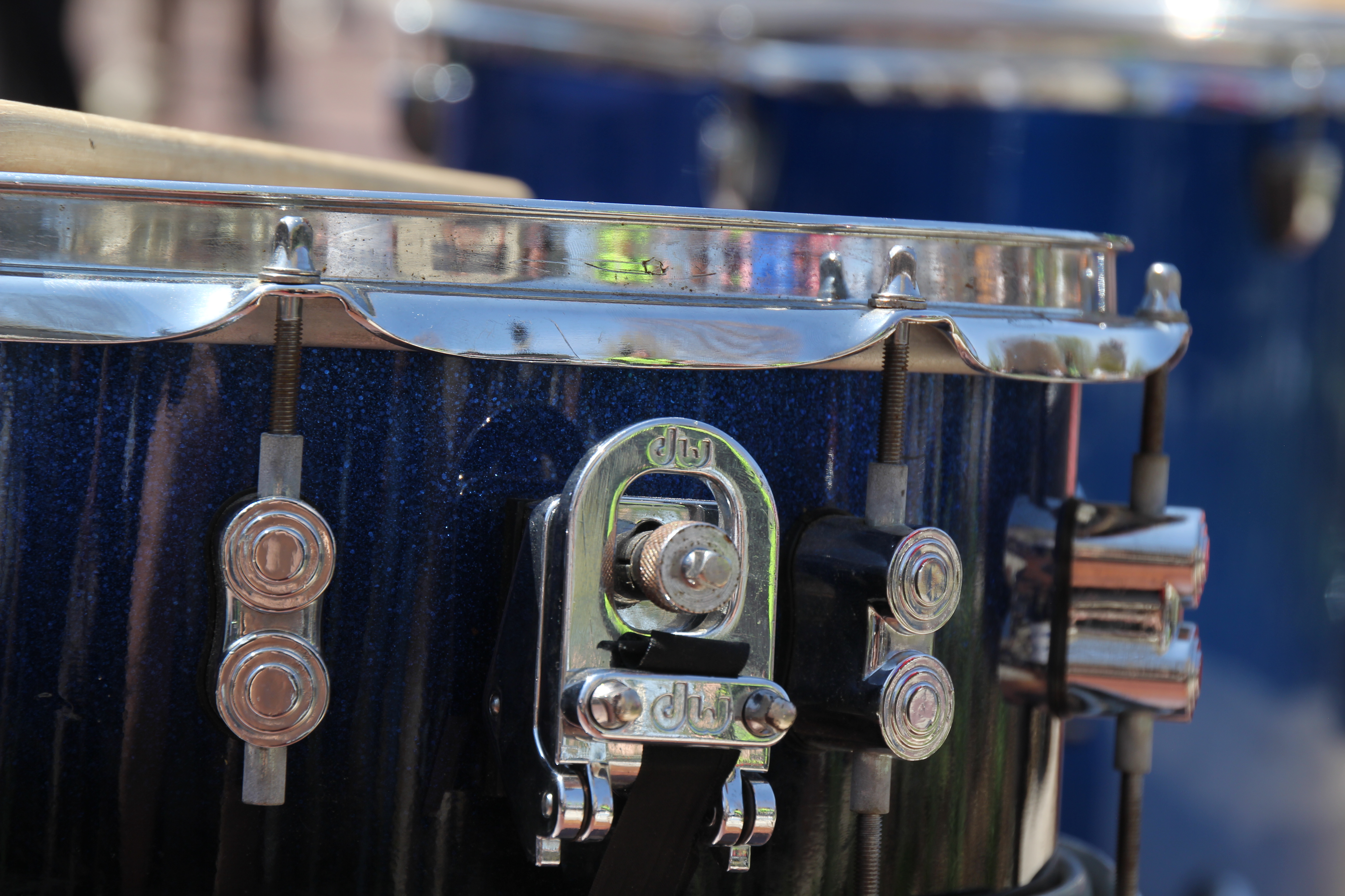 a blue drum in the foreground and in focus, another blue drum out of focus in the background